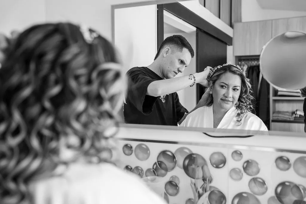 La novia se prepara para su boda, peinándose frente al espejo